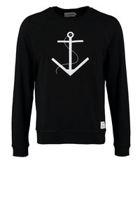 Sweatshirt noir à manches longues avec un grand graphique d'ancre blanche et une petite étiquette blanche près de l'ourlet.