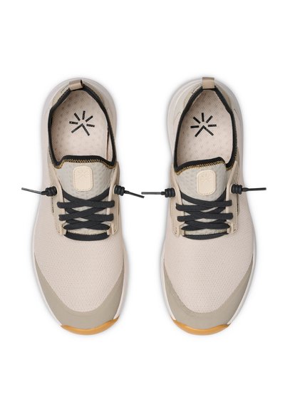 Paire de chaussures de sport en maille beige et grise avec des lacets noirs et des semelles orange, vues de dessus sur un fond blanc.