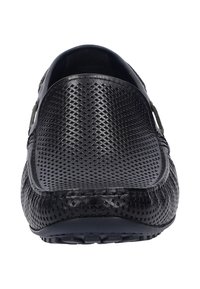 Schwarze Leder-Slipper mit einem perforierten Oberdesign, strukturierten Seiten, flacher Gummisohle und minimalen Akzentdetails.
