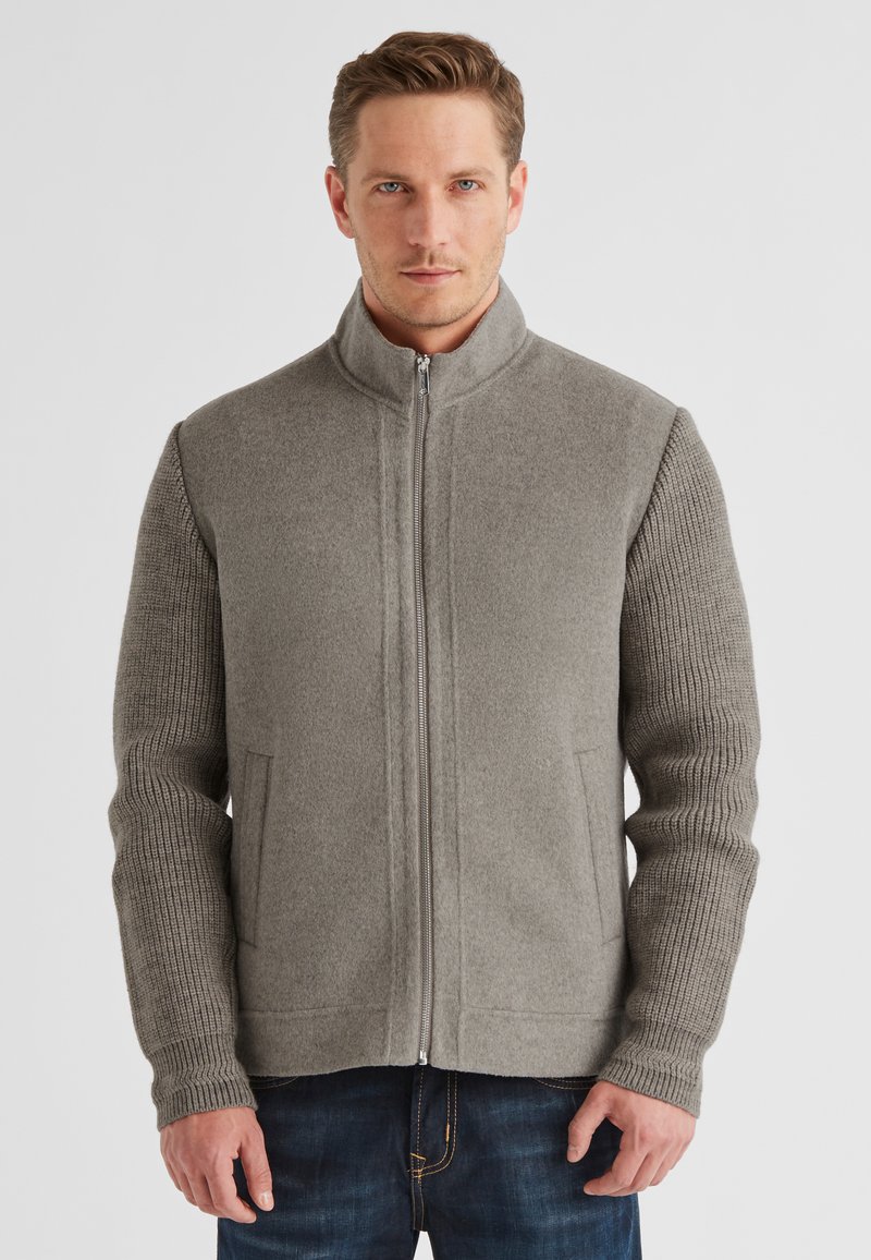 Grau geschnittener Reißverschlussjacke mit einem glatten Fleece-Körper und gerippten Ärmeln. Verfügt über seitliche Taschen und einen hohen Kragen für Wärme.