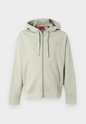 Hanorac gri deschis cu fermoar, buzunare frontale, glugă cu șnur, manșete elastice și un logo discret al brandului pe piept.