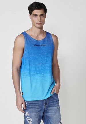 Blue gradient tank top with a round neck, featuring a subtle texture, black logo "Kroshi Brand" on the chest, paired with distressed jeans.