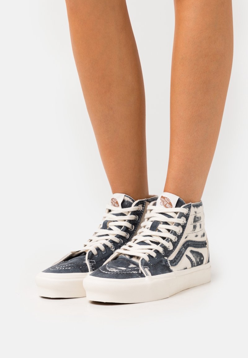 Höga sneakers i denim i en blå och vit färgskala. Har vita snören, en vadderad krage och en förstärkt tåhätta.