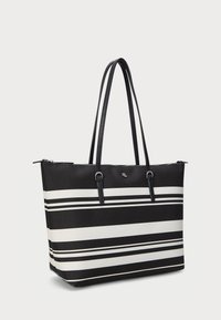 Juoda ir balta dryžuota tote maišas su dviem juodais petnešomis, su užtrauktuku ir elegantiška stačiakampio forma. Lygi tekstūra su logotipo detale.