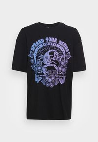 Camiseta de algodón negra con un diseño gráfico en degradado púrpura, que incluye mariposas y un escorpión, con el texto "Abre tus alas."
