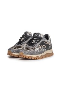 Un paio di sneaker nere e beige con motivi a stampa animale, lacci neri e suole spesse marroni con battistrada su sfondo bianco.