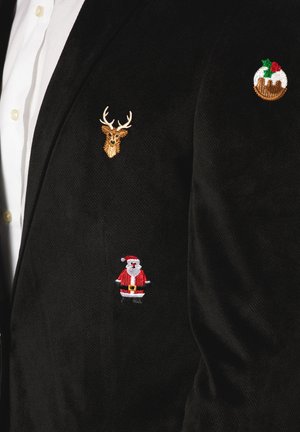 Black corduroy jacket featuring three embroidered patches: a gold deer head, a red Santa, and a round Christmas pudding with holly.