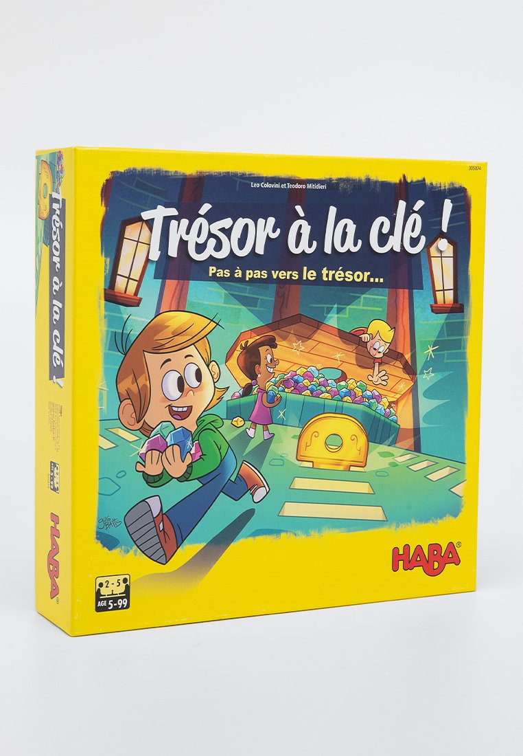 Die Brettspielbox mit dem Titel "Trésor à la clé!" zeigt farbenfrohe Cartoon-Grafiken von Kindern, einer Schatzkiste und Edelsteinen vor einem gelben Hintergrund.