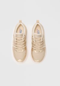 Kaksikko beige Skechers BOBS -muistipehmustettuja tennareita nauhoilla valkoista taustaa vasten, nähtynä ylhäältä päin.