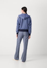 Mjölkblå hoodie med matchande byxor, som har en geometrisk design, vita sidostråk och ribbade mudd och midja.