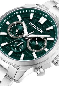 Kvarcinis chronograph laikrodis su žaliu tekstūruotu ciferblatu, sidabro spalvos valandų žymekliais ir nerūdijančio plieno apyranke. Yra dienos/datos subdailiai.