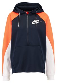 Felpa con zip blu navy con maniche raglan arancioni e bianche, dotata di una grande tasca frontale e del logo Nike sul petto. Dettagli in tessuto testurizzato.