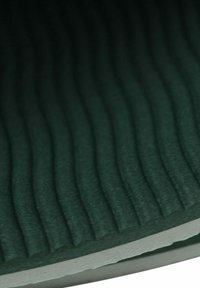 Materiale verde scuro texturizzato con motivi ondulati, design stratificato e un bordo bianco contrastante, che suggerisce profondità e qualità tattile.