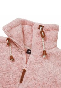 Giacca in pile rosa fluffy con colletto alto, chiusura con zip e dettagli in pelle marrone sulla zip e sui cordini. Tessuto morbido e texturizzato.