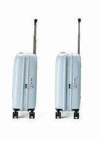 Valigia rigida di colore azzurro chiaro, dotata di manico telescopico, chiusura con zip, lucchetto a combinazione e base con quattro ruote per una facile mobilità.