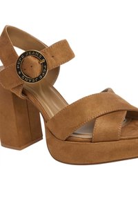 Sandali platform in suede marrone con punta arrotondata, ampie cinghie incrociate, cinturino alla caviglia e un accento a forma di cerchio sul fermaglio.