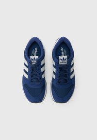 Μπλε αθλητικά παπούτσια με συνδυασμό υφασμάτων mesh και σουέντ, με τρεις λευκές ρίγες, στρογγυλά κορδόνια και ενισχυμένη σόλα.