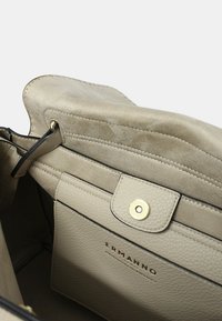 Borsa a tracolla in pelle beige con interni in morbida suede, chiusura a scatto magnetica e logo impresso. Design strutturato con tasche interne.