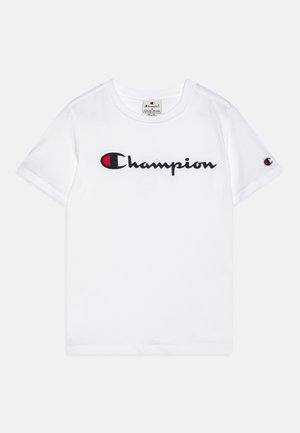 Camiseta de algodón blanca con un logo negro en cursiva de "Champion" con un acento rojo. Mangas cortas y cuello redondo clásico.