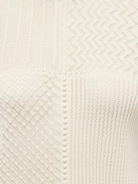 Tissu tricoté de couleur crème avec quatre motifs distincts de dentelle géométrique disposés en sections carrées.