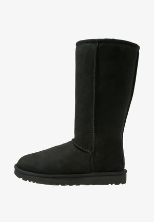 Must ja sueded kõrge saapad, millel on ümar varvas, õmmeldud õmblused ja tekstuuriga kummitald. Lihtne disain, ilma dekoratiivsete elementideta.