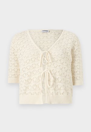 Κρεμ χρωματιστή πλεκτή ζακέτα με κοντά μανίκια, V-λαιμόκοψη, ανοιχτό μπροστινό μέρος και δύο φιόγκους δεμένους στο κέντρο.