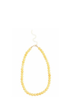 Yellow bead necklace featuring round beads with a smooth texture, finished with a gold-tone clasp and adjustable chain.