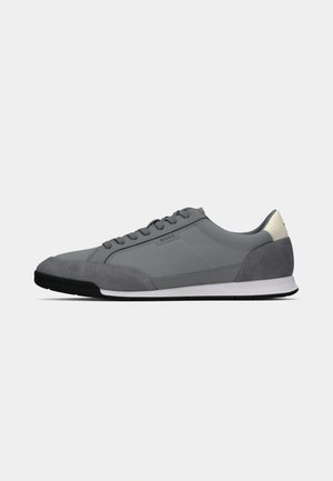 Gray athletic shoe with a suede and synthetic upper, round toe, flat lace closure, and contrasting white sole. Minimalist design.