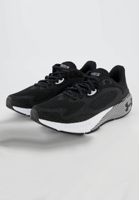 Scarpe da corsa nere con tomaia in rete, design testurizzato, suola intermedia bianca e suola con motivo. Lacci in tonalità scura e dettagli coordinati.