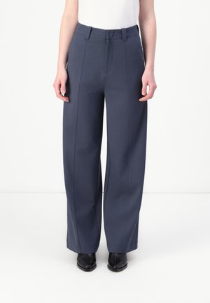 Wide-leg, navy trousers made from textured fabric. Features a flat front, belt loops, and crease detailing along the legs.