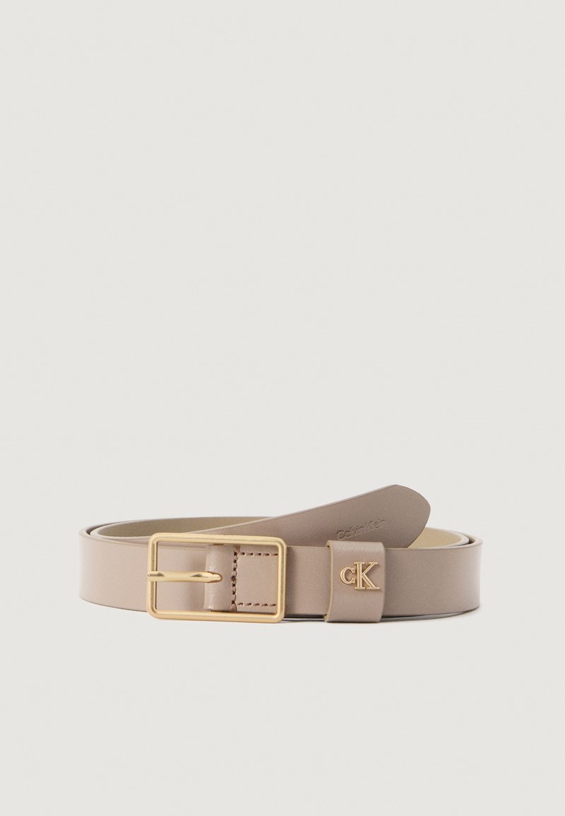 Calvin Klein bézs bőr öv aranyszínű fém csattal, logó díszítéssel és sima felülettel, klasszikus formában tervezve.