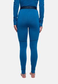 Leggings thermiques bleus en matériau doux, avec une coupe ajustée et une large taille élastique avec une marque, sans coutures aux chevilles.