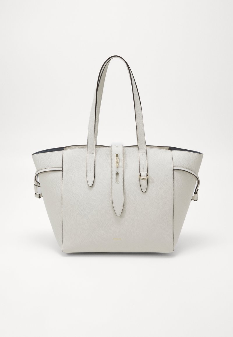 Sac cabas en cuir gris clair avec double bandoulière et une sangle centrale à boucle sur fond blanc uni.