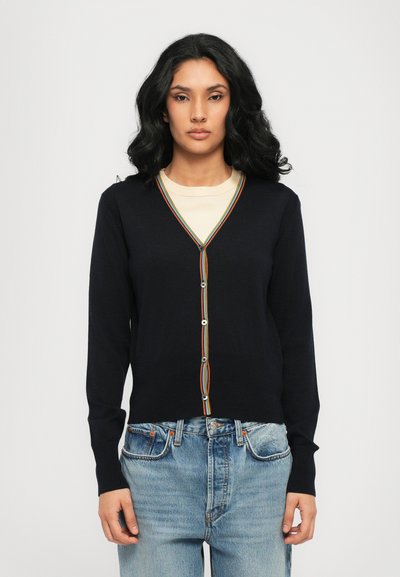 Cardigan azul marino con escote en V y un ribete a rayas de colores a lo largo de la botonera, con cierres de botones y mangas largas. Tejido de punto suave.