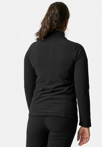 Zwarte fleecejack met hoge kraag, lange mouwen en een zachte textuur. Heeft een slimfit ontwerp en discrete stikdetails.