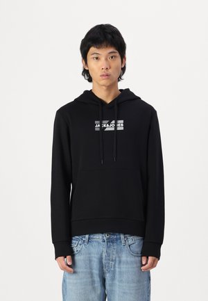 Sudadera negra hecha de tela suave, con un bolsillo frontal y capucha ajustable con cordón. Presenta un logotipo blanco en contraste en el pecho.
