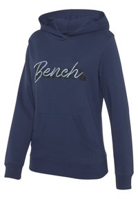Marineblaue Kapuzenjacke aus weichem Material, mit einer Fronttasche und aufgesticktem "Bench."-Logo in kontrastierenden Farben. Kapuzendesign mit gerippten Bündchen.