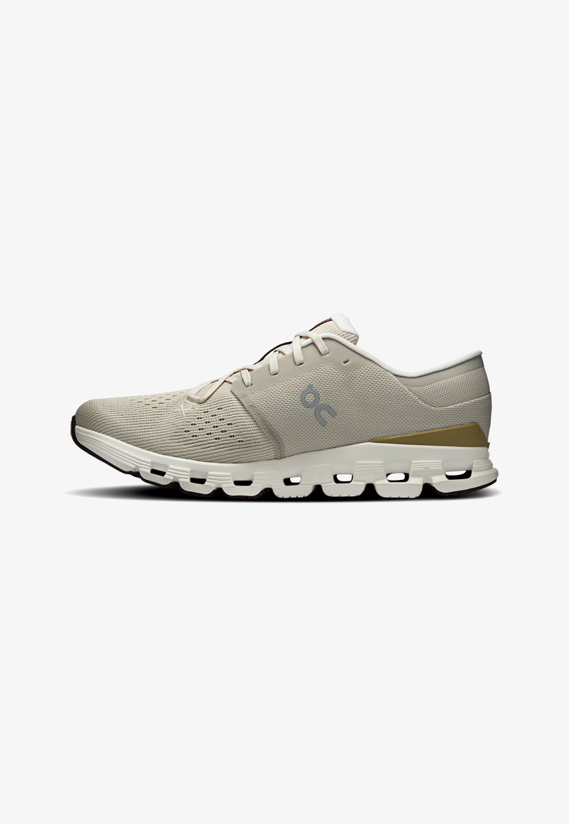 Chaussure de sport beige clair avec tige en mesh, design texturé, col rembourré et semelle blanche avec composants de coussinage visibles.
