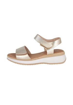 Sandalia femenina metálica dorada con punta abierta, correas ajustables en el tobillo y en el empeine, plantilla acolchada y suela plataforma blanca con dibujo beige.