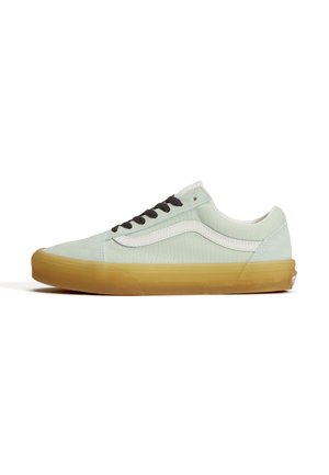 Low-top sneaker met lichtgroen canvas bovenwerk, witte zijstreep, zwarte veters en gumrubberen zool op een witte achtergrond.