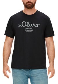 Must mustern T-särk koos ümmarguse kaeluse ja lühikeste varrukatega. Halli värviga trükitud tekst "s.Oliver Elevated Essentials Since 1969."