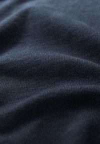 Tessuto blu scuro con una finitura a coste fine, che mostra una superficie morbida e liscia e una leggera lucentezza. Nessun motivo o accentuazione prominente visibile.