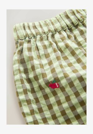 Rohelise ja pruuni ruudulise mustriga kangas elastse vöökohaga, millel on külje peal väike tikitud punane kirsi detail. Pehme tekstuur.