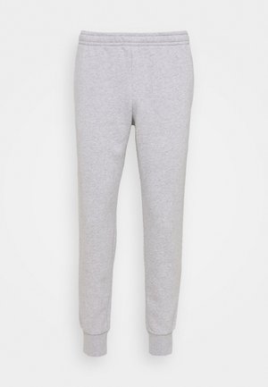 Sive bombažne trenirke z elastiko v pasu in rebrastimi manšetami, ki se ponašajo z gladko teksturo in preprostim dizajnom. Brez vidnih vzorcev ali dodatkov.