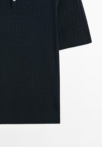Polo blu navy a maniche corte con un motivo a trecce testurizzato, caratterizzato da due bottoni bianchi al colletto e un orlo a costine.