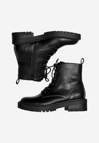 Botas de tobillo de cuero negro con cordones en la parte frontal, cremallera lateral y tacón cuadrado. Presentan una textura suave y una suela resistente con dibujo.