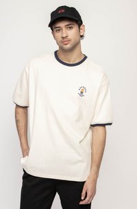 Cream-colored cotton t-shirt with navy blue collar and sleeve hems. Features a small graphic with stars and a flame design on the chest.