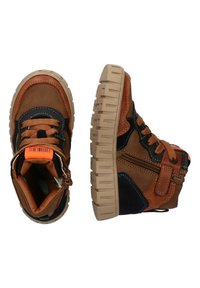 Zapatillas altas marrones con acentos negros, cuero texturizado, etiqueta naranja y suelas de goma gruesas con un diseño en zigzag y un detalle de cremallera.