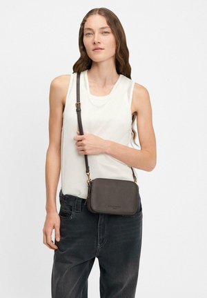 Braune Leder-Crossbody-Tasche mit rechteckiger Form, goldfarbenen Beschlägen und verstellbarem Tragegurt. Die Tasche zeichnet sich durch eine glatte Textur und dezente Markenkennzeichnung aus.