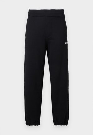 Pantaloni della tuta neri con vita e polsini elastici, caratterizzati da un piccolo logo bianco sulla parte superiore della coscia sinistra.